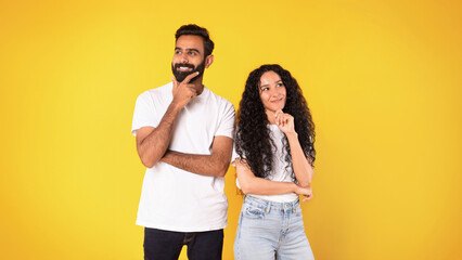 Wall Mural - Pensive positive middle eastern couple thinking on yellow background