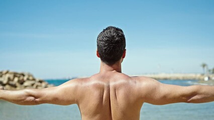 Sticker - Young hispanic man tourist standing shirtless doing yoga exercise at the beach