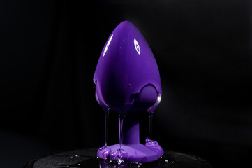 Wall Mural - Intimate lubricant pours on a purple anal plug on a black background. Copy space. 