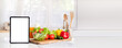Tablet computer, plate with fresh salad and different products in kitchen background with space for text. tablet with mockup white screen on vegetarian healthy food vegetable background.