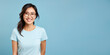 Attractive asian woman wearing blue tshirt and glasses. Isolated on blue background. 