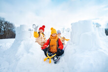 Group Of Children Make Snowballs For Snowball Fights. Children Play In Snow Fort Made Of Ice Blocks. Active Winter Outdoor Games.