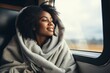 © Stavros - Young African American woman rides a train, smiling thoughtfully, looking out the window. Journey alone with yourself and your thoughts. Digital detox and offline concept.