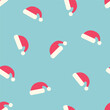 Seamless pattern with Santa Claus hats on a blue background. winter vector illustration.