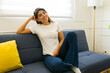 © AntonioDiaz - Young woman relaxing on the sofa with a white mockup t-shirt