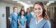 © elovich - Portrait of young female doctor, nurse, with colleagues in the background