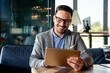 © NDABCREATIVITY - Portrait of young business man working on digital tablet
