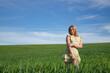 © Manuel - Young, beautiful, blonde woman in a yellow dress, with an ear of corn in her mouth in the middle of a green wheat field, very smiling and happy. Concept beauty, happiness, peace, fields, meadows.