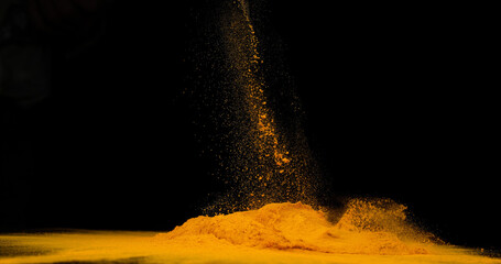 Wall Mural - Turmeric, curcuma longa, Powder falling against Black Background, Indian Spice