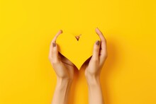 Hands making heart shape isolated on a yellow background