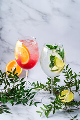 Canvas Print - Cocktails Aperol Spritz with orange and Mojito with mint and lime on the table.