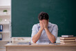 © Elnur - Young male teacher in front of green board