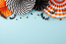 Join For A Night Of Ghoulish Delight At Halloween Celebration. Top View Flat Lay Of Folding Paper Fans, Halloween Decorations On Light Blue Background With Empty Space For Advert Or Text