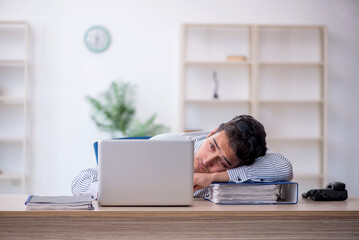 Wall Mural - Young male employee working in the office