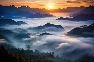 Wall Mural - a high view sunrise or sunset over a mountain range low lying fog with mountain in silhouette, stunn