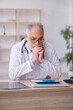 © Elnur - Old male doctor sitting in the clinic