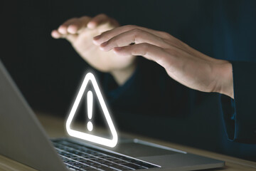 Wall Mural - businessman using laptop showing warning triangle and exclamation sign icon warning of dangerous pro