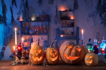 Wall Mural - Halloween pumpkins with candles and magic potions at night indoor