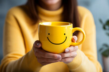 Happy Tea Drink With Happy Emoji Face On Big Yellow Cup In Woman's Hands. The Most Happiest And Coffee Good Vibes Motivation. Copy Space, Empty Place For Text. Generative AI