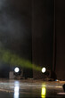 An empty concert stage illuminated by spotlights and smoke before the show.