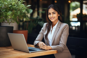 Wall Mural - Young indian businesswoman or corporate employee using laptop