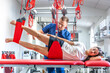 © puhimec - A young female is doing exercises with special ropes in rehabilitation center.