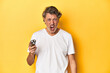 © Asier - Man holding a razor, yellow studio background screaming very angry and aggressive.