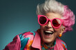 Happy, cool, fashionable old lady in outrageous pink clothes and sunglasses.