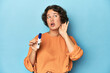 © Asier - Young woman holding pregnancy test, studio background trying to listening a gossip.