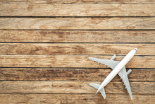 Airplane Model On A Wooden Background, Top View, Copy Space.