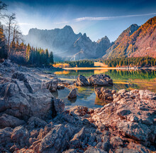 Calm Autumn View Of Fusine Lake. Dramatic Morning Scene Of Julian Alps With Mangart Peak On Background, Province Of Udine, Italy, Europe. Traveling Concept Background.