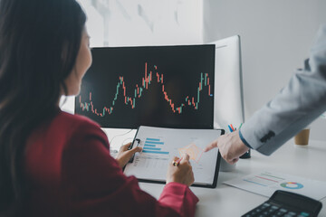 Two investors look at stock insights to analyze risk, stock investing businessman analyzing stock market rise and fall chart, stock market investor, profit making. investment concept.