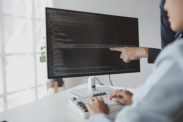 Wall Mural - Two programmers looking at computer screen, programmer design custom computer programming, programming code and website. Computer programming design concepts.