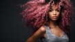 This is a stunning African-American woman with light brown, pink, and curly hair against a dark backdrop.