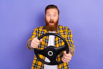 Wall Mural - Portrait of impressed speechless person open mouth hands hold steering wheel isolated on purple color background