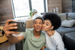 © LIGHTFIELD STUDIOS - african american couple pouting lips while taking selfie on smartphone in new living room