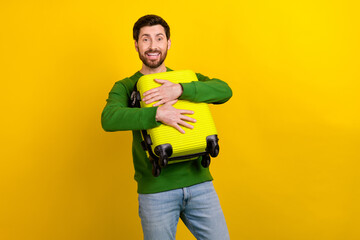 Canvas Print - Photo of cheerful man wearing stylish green clothes hold suitbag enjoy summer adventure relax rest isolated on yellow color background