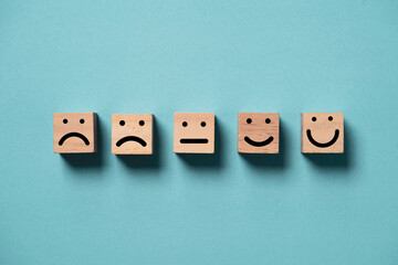 Poster - Human face from sad to smile  print screen on wooden block cube face on blue background for positive thinking and excellent evaluation rating after use product and service concept.
