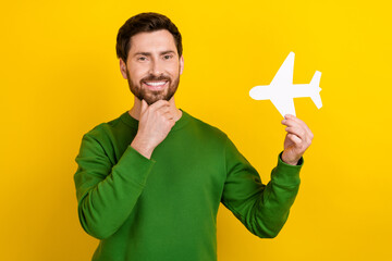 Poster - Photo of glad minded man traveler wear trendy green clothes choose airline fly abroad isolated on yellow color background