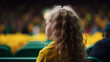 © ImageHeaven - Back view of a girl in yellow and green, watching the Australian team play at the Women's World Cup, with the stadium in the background.