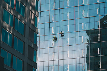 Wall Mural - architecture - city skyline skyscrapers with window washers hanging on side of building with reflect