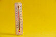 Wooden outdoor thermometer yellow background.