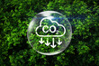 © surasak - CO2 emission reduction sign and arrows down with earth globe on green leaf background for CO2 reduction in environmental concept ,carbon footprint, renewable energy business.Global warming.