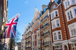 The streets of London England with the Union Jack flying in front of luxury flats and stores. 