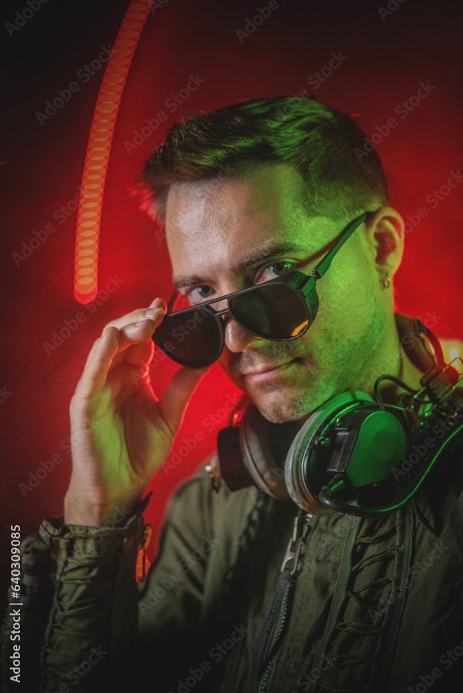 Pilot man concept. The man in the high altitude compensating suit posing on the old iron industrial fan background.