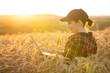 © scharfsinn86 - Woman farmer working with laptop on wheat field. Smart farming and digital agriculture..
