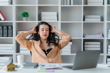 tired business woman sleepy and bored from sitting at a desk for a long time and has office syndrome