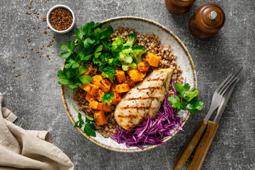 Wall Mural - Grilled chicken breast with buckwheat, roasted butternut squash, broccoli, fresh greens and red cabbage. Healthy food, lunch menu, top view