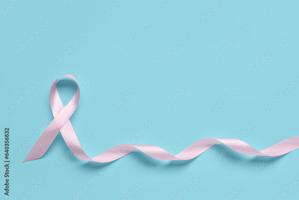Pink awareness ribbon on color background. Breast cancer concept