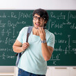 © Elnur - Young male student mathematician in front of chalkboard